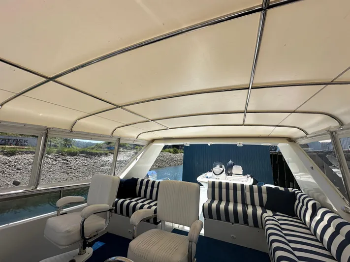 Safari Yacht Photos Pics Luxurious interior of 2001 Symbol 66 Pilothouse Yacht with striped seating and panoramic windows.