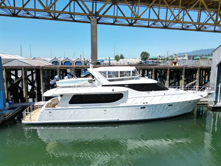 Safari Yacht Photos Pics 2001 Symbol 66 Pilothouse Yacht docked under a metal structure.