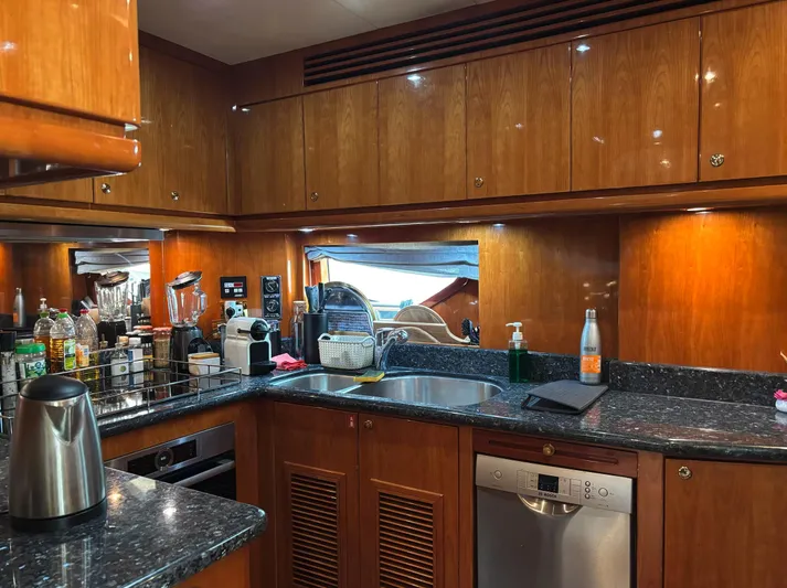  Yacht Photos Pics Luxurious kitchen interior of 2005 Monte Fino 82 yacht with wooden cabinets and modern appliances.