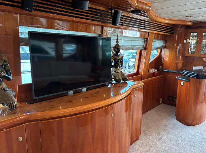 Yacht Photos Pics Luxurious interior of 2005 Monte Fino 82 yacht with elegant wood finish and modern TV setup.