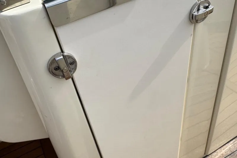  Yacht Photos Pics Close-up of a 2013 Chris-Craft Launch 28 boat's white exterior with metal latch details.