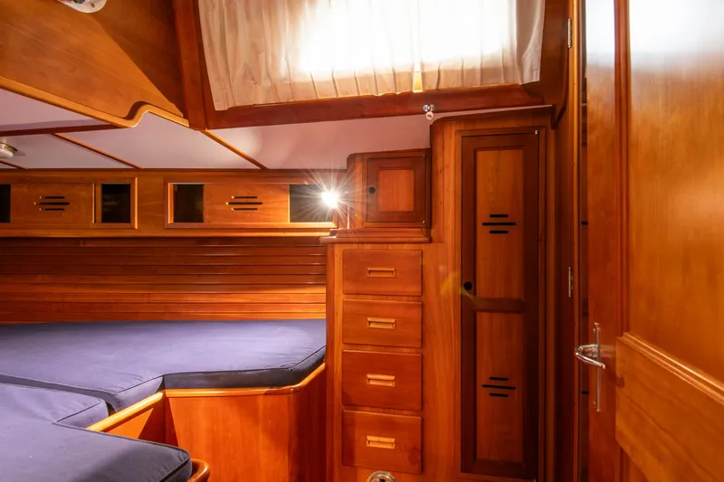 Regulus Yacht Photos Pics Hinckley Sou'wester 51 (1993) cabin interior with wooden cabinetry and blue cushions.