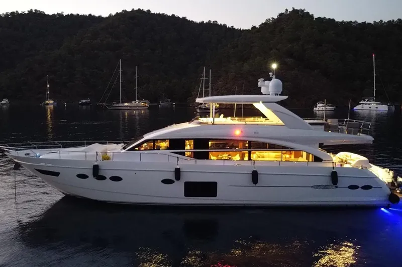 On Yacht Photos Pics Luxurious 2014 Princess 82 yacht illuminated at dusk, anchored in a serene bay.