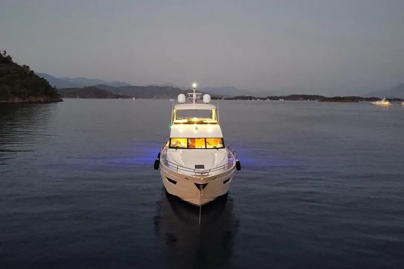 On Yacht Photos Pics Luxurious 2014 Princess 82 yacht illuminated on serene waters at dusk.