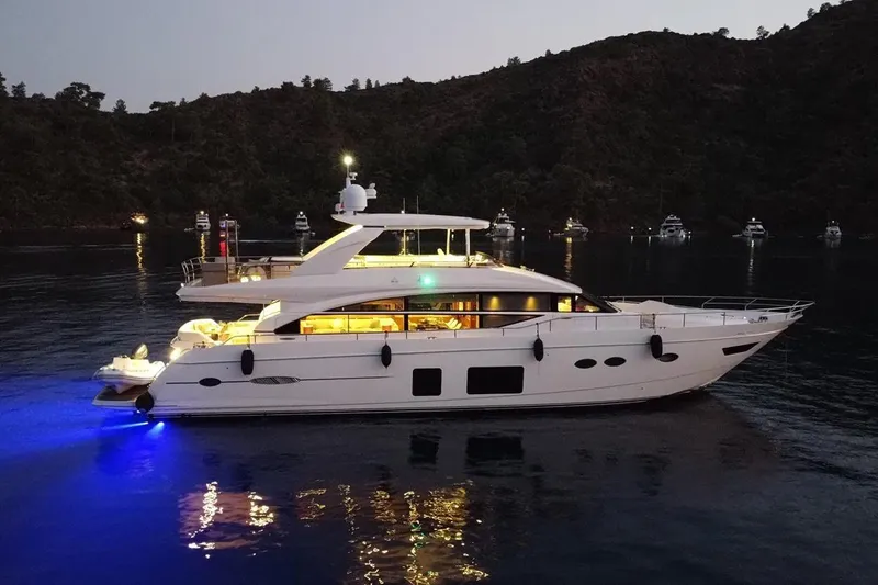 On Yacht Photos Pics Luxurious 2014 Princess 82 yacht illuminated at night, anchored in serene waters.