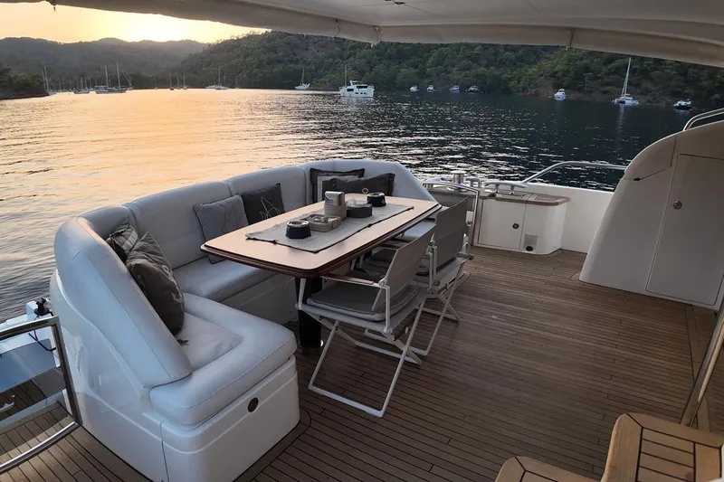 On Yacht Photos Pics Luxurious 2014 Princess 82 yacht deck with elegant seating, overlooking serene waters at sunset.