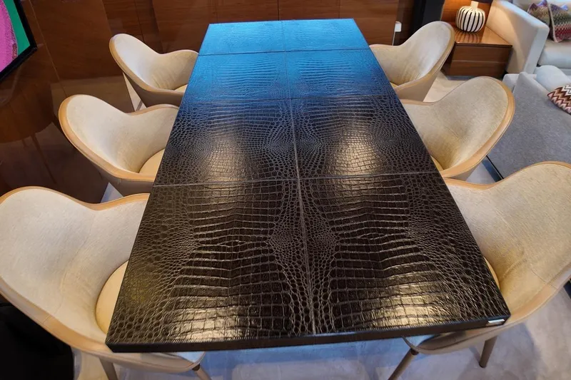On Yacht Photos Pics Luxurious dining table with crocodile-patterned surface and elegant chairs on a Princess 82 yacht.