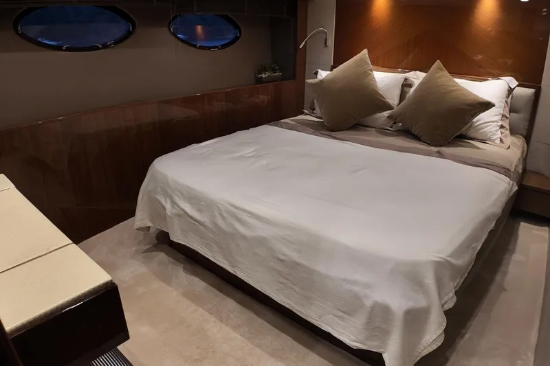 On Yacht Photos Pics Luxurious bedroom interior on a 2014 Princess 82 yacht, featuring elegant bedding and ambient lighting.