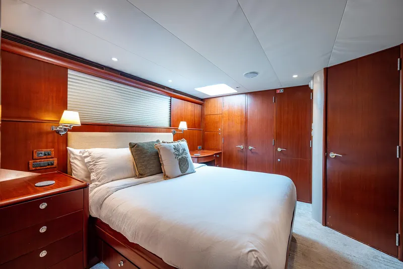 Lady Lorraine Yacht Photos Pics Luxurious bedroom in 2007 Cheoy Lee Bravo Flybridge Motor Yacht with wooden cabinetry and modern lighting.