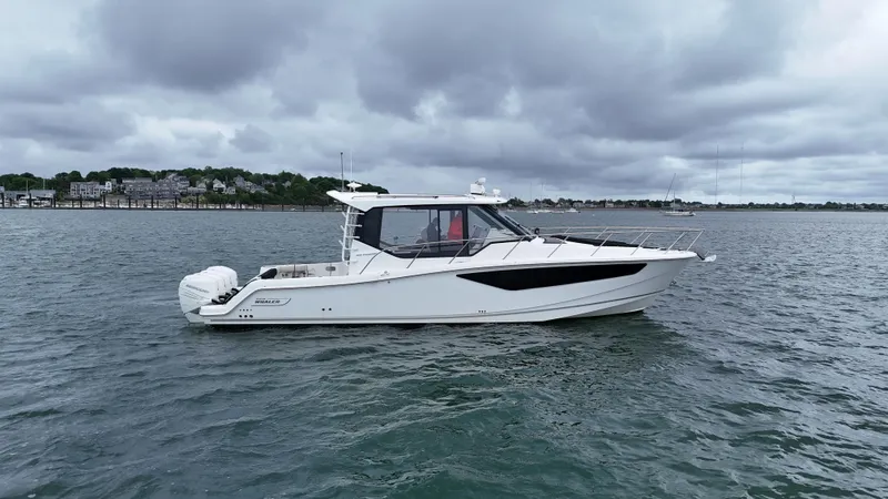  Yacht Photos Pics 2021 Boston Whaler 405 Conquest boat on calm water under cloudy skies.