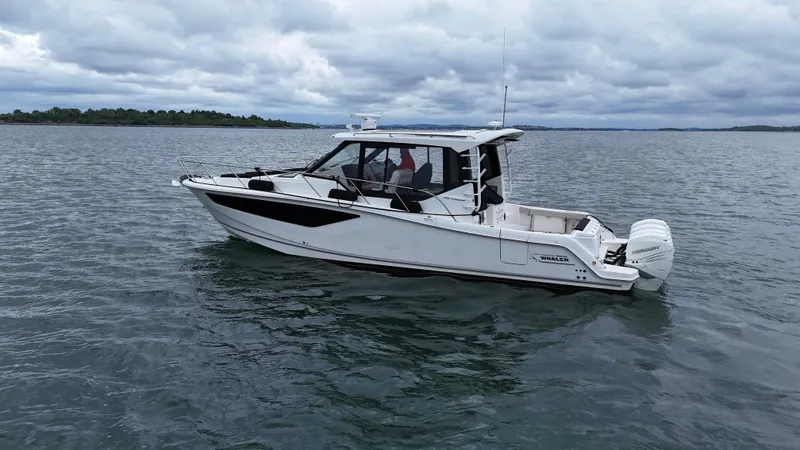  Yacht Photos Pics 2021 Boston Whaler 405 Conquest boat on calm water under cloudy sky.