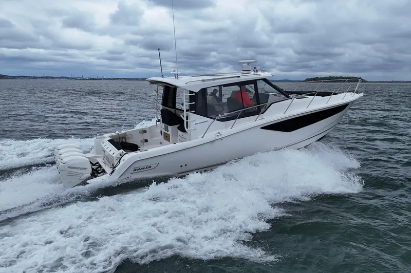  Yacht Photos Pics 2021 Boston Whaler 405 Conquest cruising on open water under cloudy skies.