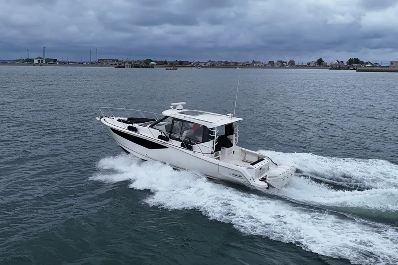  Yacht Photos Pics 2021 Boston Whaler 405 Conquest cruising on open water under cloudy skies.
