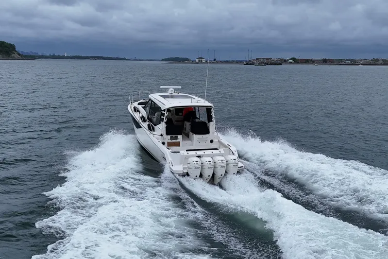  Yacht Photos Pics 2021 Boston Whaler 405 Conquest cruising on open water, rear view.