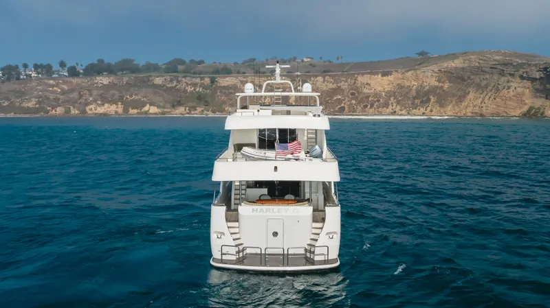 Harley G Yacht Photos Pics TransWorld 116' yacht, 2014 model, cruising on blue ocean near rocky coastline.