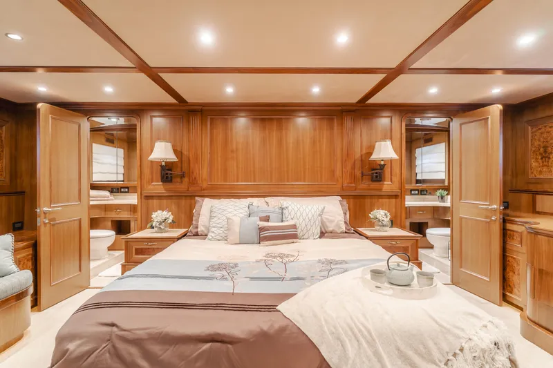 Harley G Yacht Photos Pics Luxurious bedroom interior on 2014 TransWorld 116' yacht, featuring elegant wood paneling and cozy bedding.