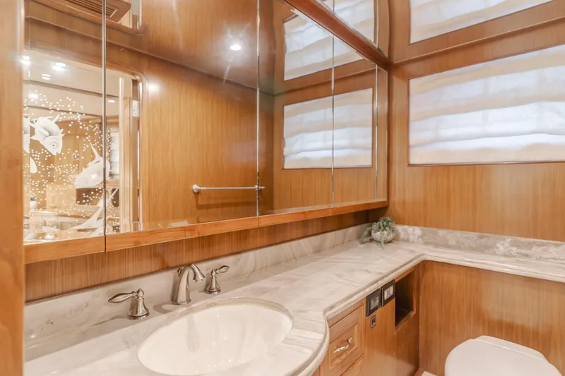 Harley G Yacht Photos Pics Luxurious bathroom in 2014 TransWorld 116' yacht with marble countertop and wooden cabinetry.