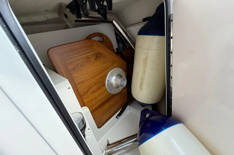  Yacht Photos Pics Storage compartment of 2025 Sea Ray SDX 270 Outboard with fenders and wooden table.