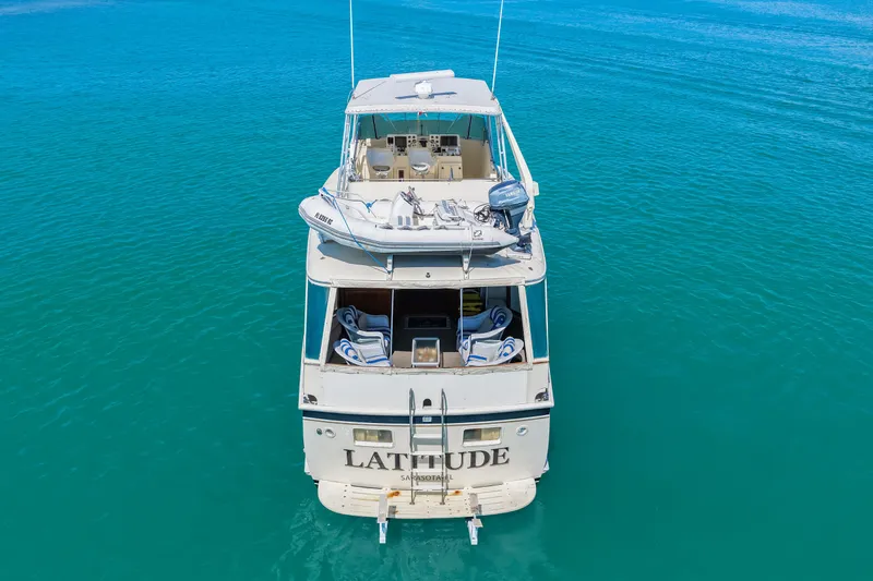 Lattitude Yacht Photos Pics 1979 Hatteras 53 Motor Yacht on clear blue water, rear view.