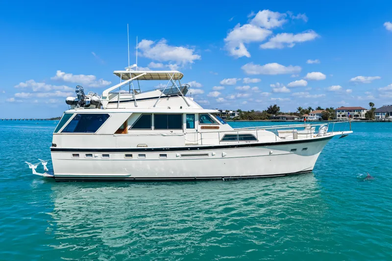 Lattitude Yacht Photos Pics 1979 Hatteras 53 Motor Yacht on clear blue water under a sunny sky.