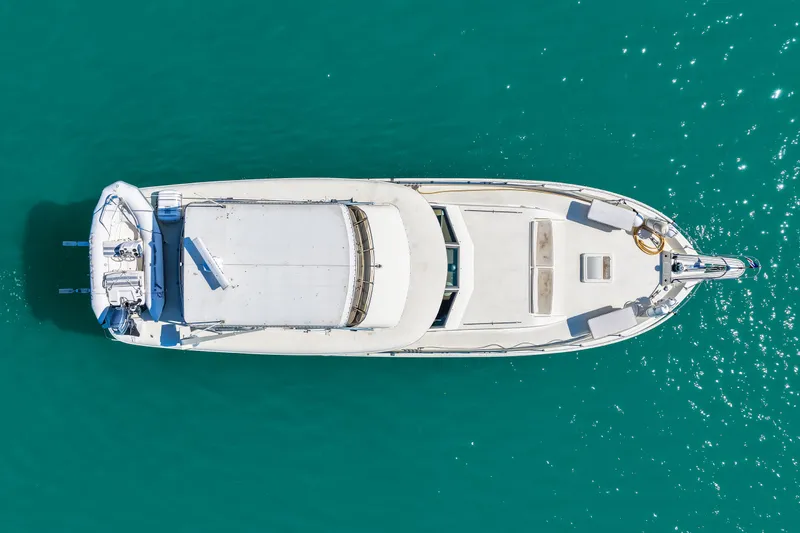 Lattitude Yacht Photos Pics Aerial view of 1979 Hatteras 53 Motor Yacht on turquoise water.