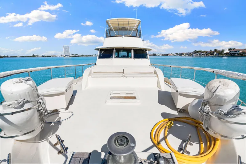 Lattitude Yacht Photos Pics 1979 Hatteras 53 Motor Yacht on clear blue water, sunny day, spacious deck view.