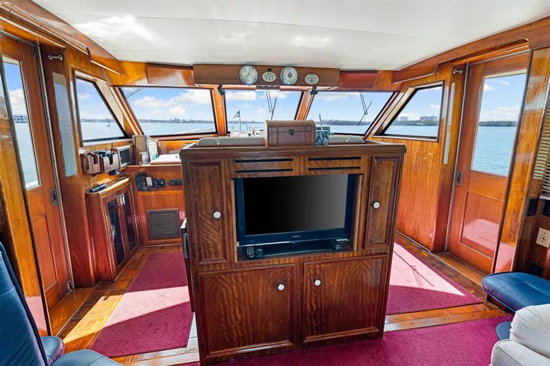 Lattitude Yacht Photos Pics Interior of 1979 Hatteras 53 Motor Yacht with wood paneling and large windows.