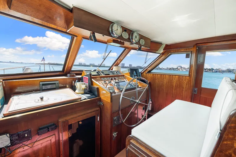 Lattitude Yacht Photos Pics Interior helm of 1979 Hatteras 53 Motor Yacht with wooden dashboard and steering wheel.