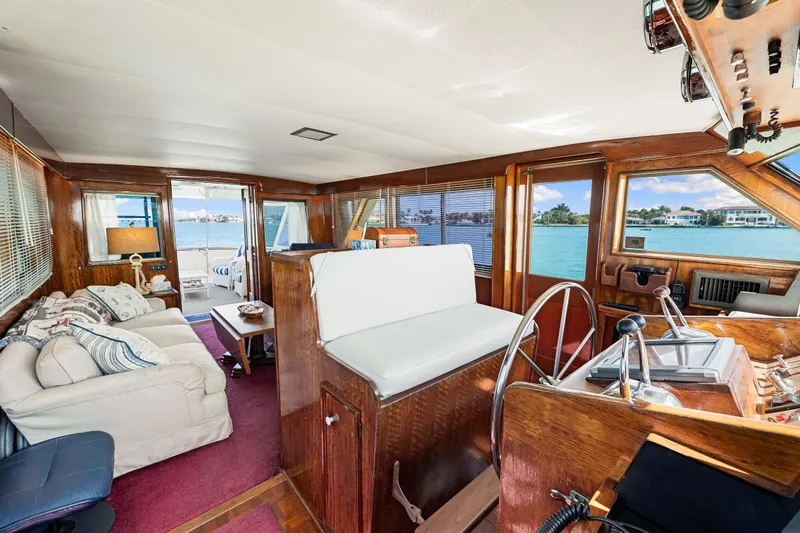 Lattitude Yacht Photos Pics Interior of 1979 Hatteras 53 Motor Yacht with elegant wood finish and waterfront view.