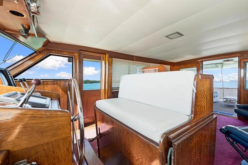 Lattitude Yacht Photos Pics 1979 Hatteras 53 Motor Yacht interior with wooden helm and white seating, ocean view.