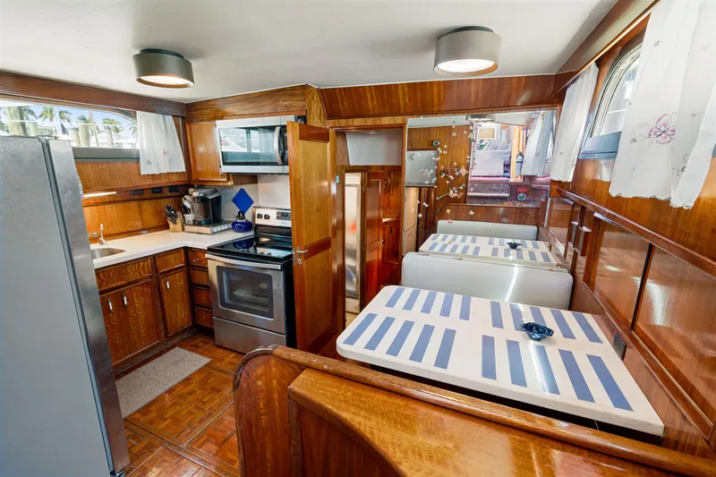 Lattitude Yacht Photos Pics 1979 Hatteras 53 Motor Yacht interior with wood cabinetry and modern kitchen appliances.