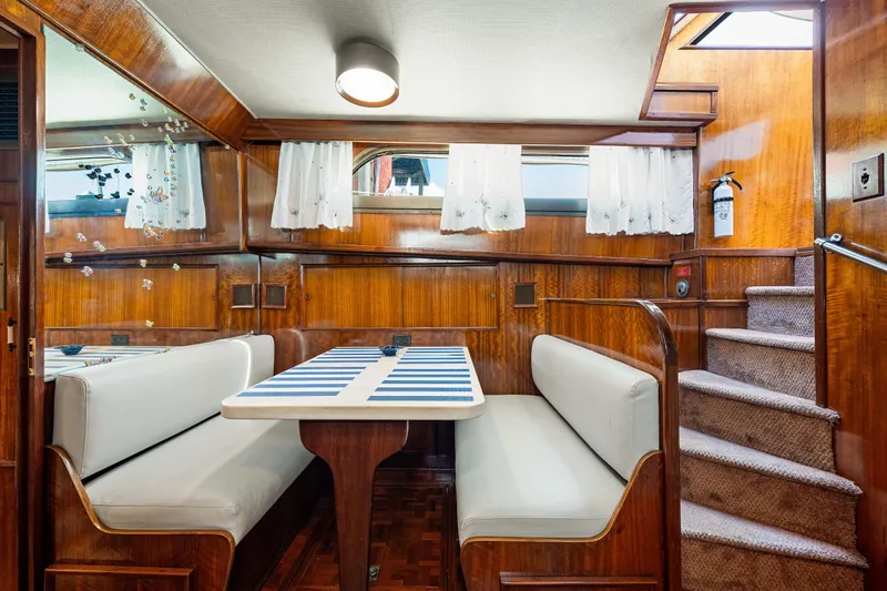 Lattitude Yacht Photos Pics Interior of 1979 Hatteras 53 Motor Yacht with dining area and wooden paneling.