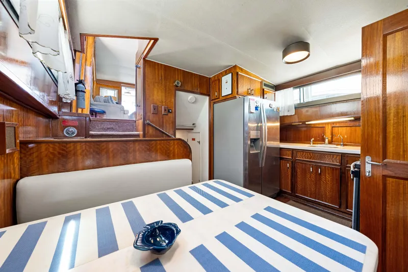 Lattitude Yacht Photos Pics 1979 Hatteras 53 Motor Yacht interior with wood paneling and modern kitchen amenities.