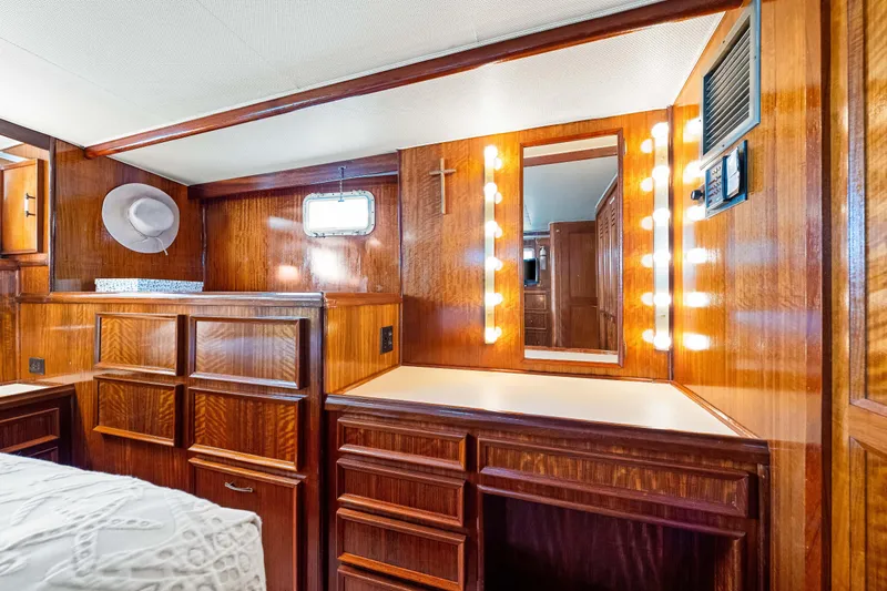 Lattitude Yacht Photos Pics Luxurious 1979 Hatteras 53 Motor Yacht interior with wood cabinetry and vanity mirror lighting.