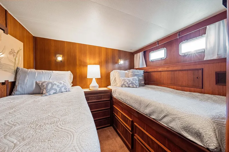 Lattitude Yacht Photos Pics 1979 Hatteras 53 Motor Yacht cabin with twin beds, wood paneling, and soft lighting.