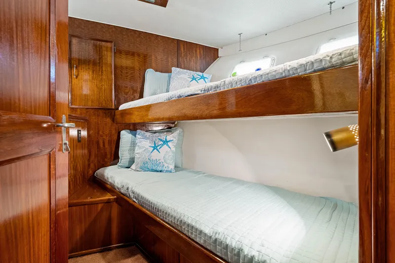 Lattitude Yacht Photos Pics 1979 Hatteras 53 Motor Yacht cabin with wooden bunk beds and nautical decor.