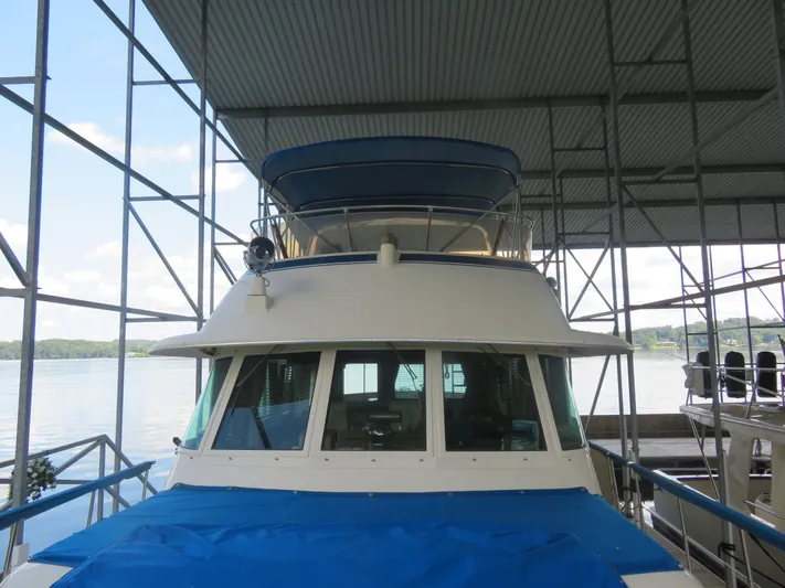 Rive' Gauche Yacht Photos Pics 1986 Hatteras 58 Motor Yacht docked under a covered marina with scenic lake view.