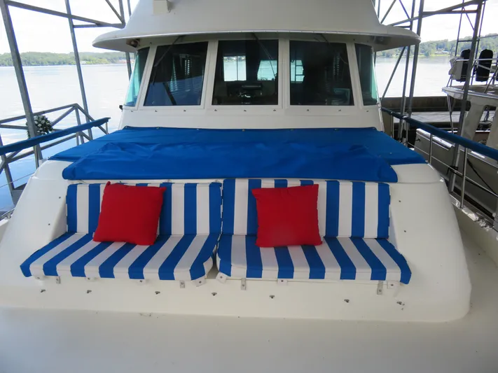 Rive' Gauche Yacht Photos Pics 1986 Hatteras 58 Motor Yacht with blue-striped seating and red cushions on deck.
