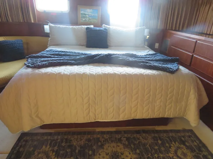 Rive' Gauche Yacht Photos Pics Luxurious bedroom interior of 1986 Hatteras 58 Motor Yacht with cozy bedding and decor.