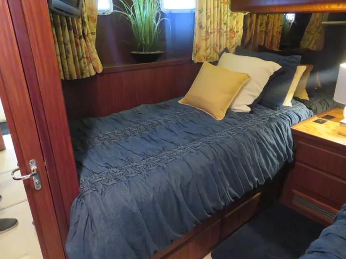 Rive' Gauche Yacht Photos Pics Cozy cabin interior of 1986 Hatteras 58 Motor Yacht with blue bedding and floral curtains.