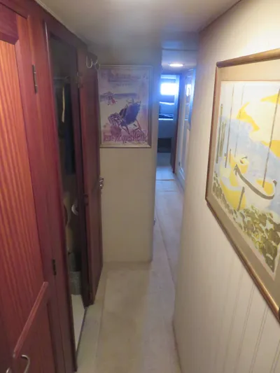 Rive' Gauche Yacht Photos Pics Narrow hallway inside 1986 Hatteras 58 Motor Yacht with artwork and wooden cabinets.