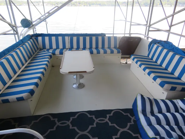 Rive' Gauche Yacht Photos Pics 1986 Hatteras 58 Motor Yacht interior with blue-striped seating and table, overlooking water.