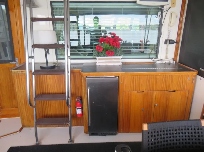 Rive' Gauche Yacht Photos Pics Interior of 1986 Hatteras 58 Motor Yacht with wooden cabinetry and red flowers.