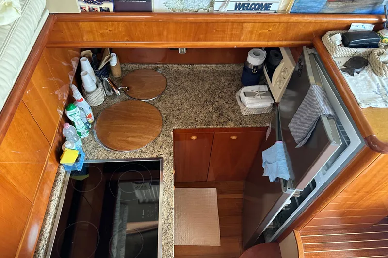  Yacht Photos Pics Compact kitchen area in a 2003 Ferretti Yachts 430, featuring granite countertops and modern appliances.
