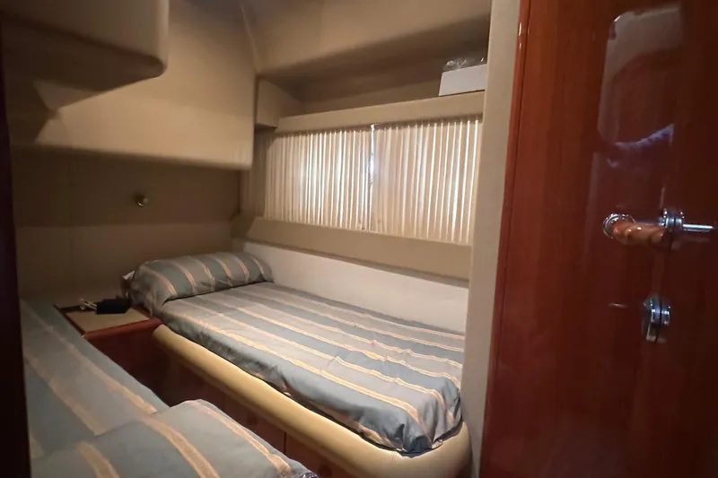  Yacht Photos Pics Cozy cabin interior of 2003 Ferretti Yachts 430 with twin beds and striped bedding.