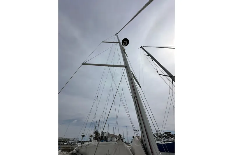  Yacht Photos Pics Mast of 2019 Jeanneau Sun Odyssey 440 sailboat against cloudy sky.