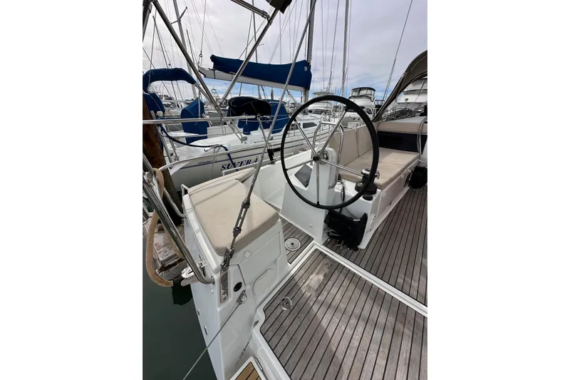  Yacht Photos Pics 2019 Jeanneau Sun Odyssey 440 sailboat cockpit with steering wheel and seating, docked in marina.