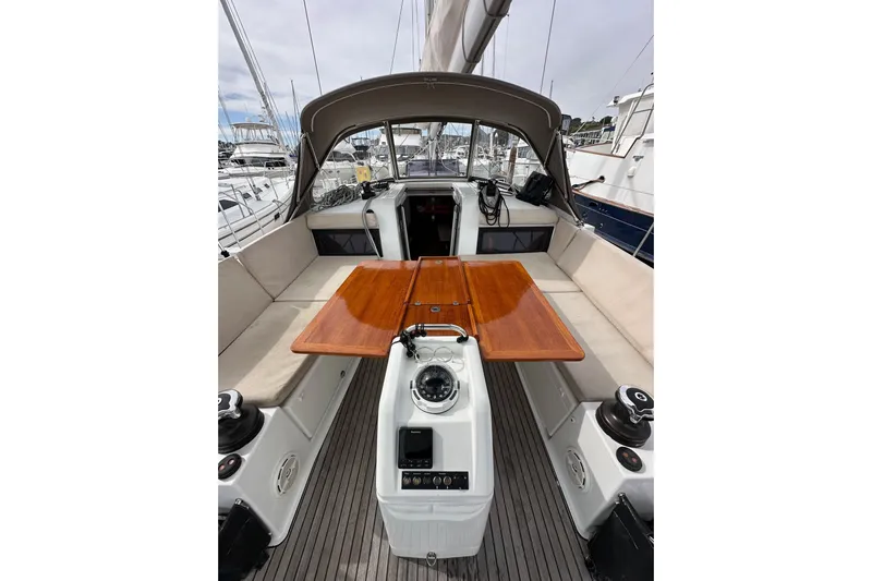  Yacht Photos Pics 2019 Jeanneau Sun Odyssey 440 sailboat cockpit with wooden table and beige seating.