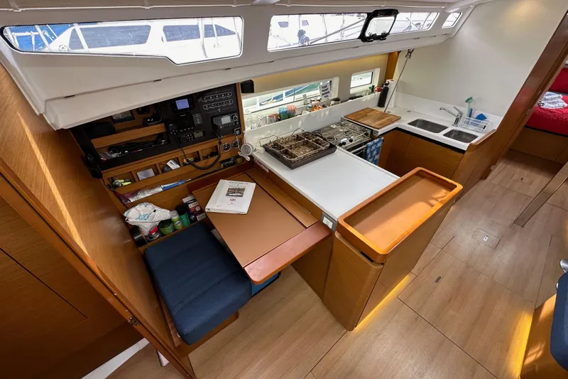  Yacht Photos Pics 2019 Jeanneau Sun Odyssey 440 interior with kitchen, navigation station, and seating area.