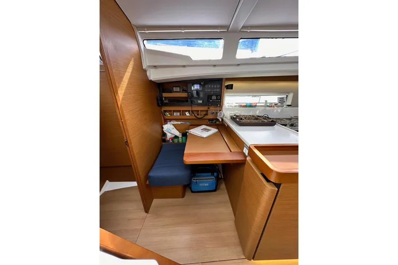  Yacht Photos Pics Interior of 2019 Jeanneau Sun Odyssey 440 sailboat with wooden cabinetry and seating area.